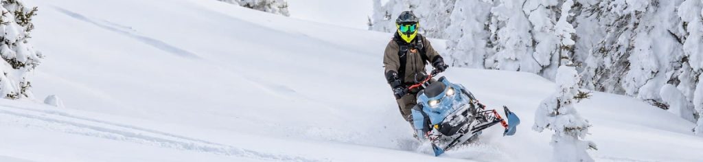 Motoneigiste dans une forêt enneigée